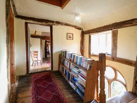 A hallway with a bookshelf and a chair at Town Farm
