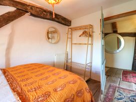 A bedroom with a quilted bed and a clothes rack at Town Farm in 