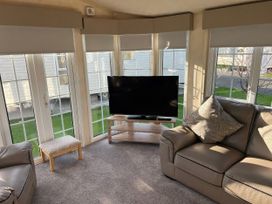 A living room with a television and sofa at Gainc Bach in Abergele