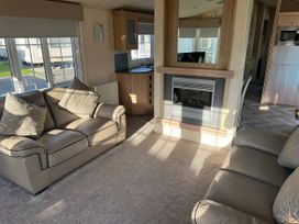 A living room with sofas and a fireplace at Gainc Bach in Abergele