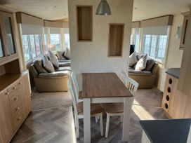 A dining area with a table and chairs at Gainc Bach Abergele