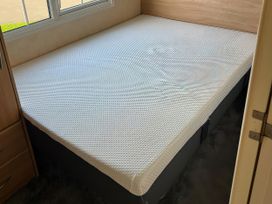 A bed with a mattress in a bedroom at Gainc Bach Abergele