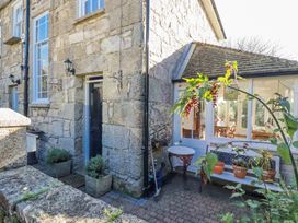 An outdoor area with a stone wall and potted plants at Rosedale in St. Ives