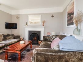 A living room with a fireplace and television at Rosedale in St. Ives