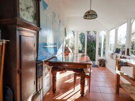 A conservatory with a table and chairs at Rosedale in St. Ives