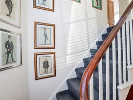 A staircase with framed pictures in a hallway at Rosedale in St. Ives
