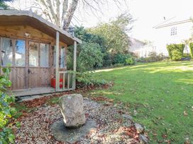 An outdoor area with a wooden cabin and stone feature at Rosedale in St. Ives