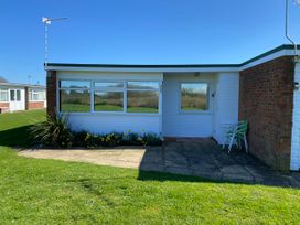 An exterior view of a property with flowers and chairs at 300 California Sands, California, Norfolk