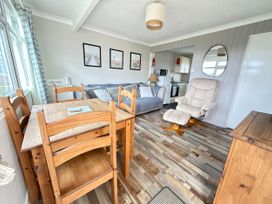 A living room with dining table and chairs at 300 California Sands in California, Norfolk
