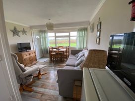 A living room with a dining table and sofa at 300 California Sands in California, Norfolk