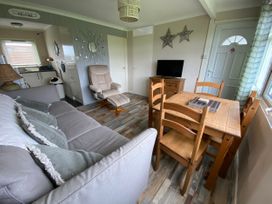 A living room with a sofa and dining table at 300 California Sands in California, Norfolk