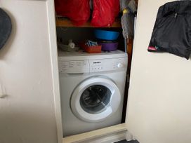 A washing machine with bowls and cleaning supplies at 300 California Sands, California, Norfolk