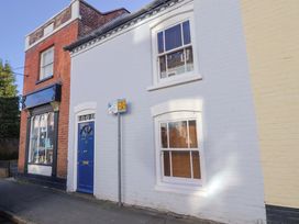 A building with a blue door and windows at Rope Cottage in Bridport