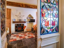A living room with a fireplace and tv at Rope Cottage in Bridport