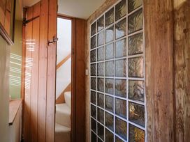 A hallway with a wooden door and glass block wall at Rope Cottage in Bridport
