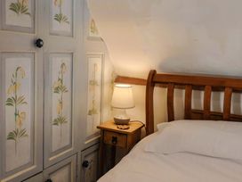 A bedroom with a bed and bedside table at Rope Cottage in Bridport