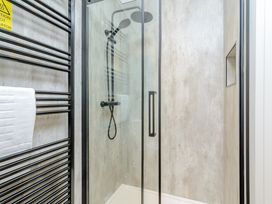 A shower with glass doors and towel rack at The Elton in Kings Cliffe