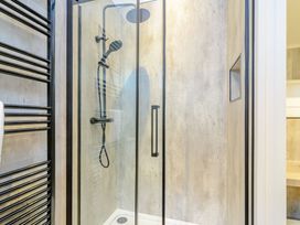 A shower with glass door and towel rack at The Castor in Kings Cliffe