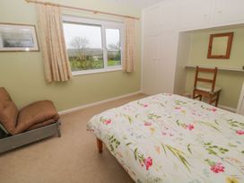 A bedroom with a bed and wardrobe at Orchard End in Launceston