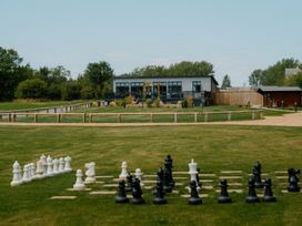 An outdoor area with life-sized chess pieces and a building at The Sutton in Kings Cliffe