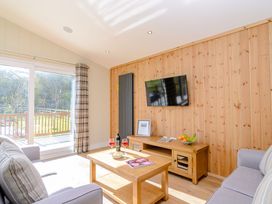 A living room with a TV on the wall and a coffee table at The Chesterton in Kings Cliffe