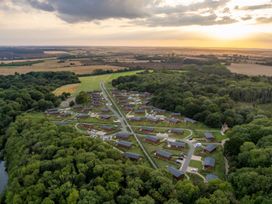 An aerial view of a cabin site surrounded by trees at The Chesterton (Pet) in Kings Cliffe