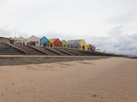 Colorful beach huts on sand at No. 30 First Avenue in Towyn
