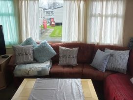 A living room featuring a sofa with cushions at No. 30 First Avenue in Rhyl