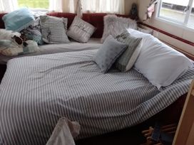 A living room with a couch and bed with pillows at No. 30 First Avenue, Rhyl
