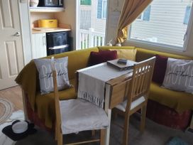 A living room with a table and chairs at No. 30 First Avenue in Rhyl