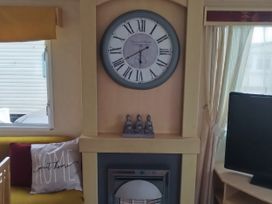 A living room with a clock and fireplace at No. 30 First Avenue Rhyl