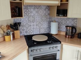 A kitchen with gas stove and coffee maker at No. 30 First Avenue Rhyl