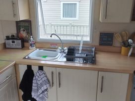 A kitchen with a sink and dish rack at No. 30 First Avenue in Rhyl