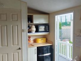 A kitchen with a microwave and refrigerator at No. 30 First Avenue, Rhyl