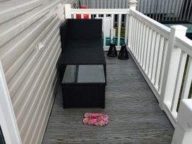 An outdoor seating area with a sofa and table at No. 30 First Avenue in Rhyl