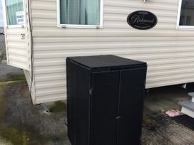 An outdoor area with a caravan and a black storage unit at No. 30 First Avenue Rhyl