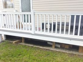 A decking area with a railing and furniture at No. 30 First Avenue, Rhyl