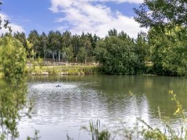 A pond with a fountain and trees at The Nassington (Pet) Kings Cliffe