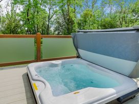 A hot tub on a deck surrounded by trees at The Wansford in Kings Cliffe
