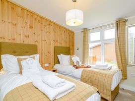 A bedroom with two beds and a window at The Wansford in Kings Cliffe