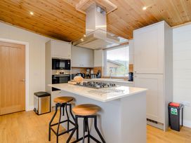 A kitchen with an island and stools at The Wansford (Pet) Kings Cliffe