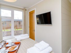 A bedroom with towels and refreshments on a tray at The Ailsworth (Pet) Kings Cliffe
