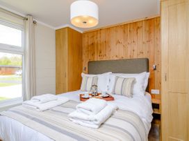 A bedroom with a bed and window at The Ailsworth (Pet) in Kings Cliffe