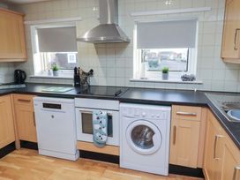 A kitchen with appliances including a dishwasher and washing machine at Beadlin cottage Beadnell