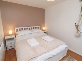 A bedroom featuring a bed with bedding and nightstands at Beadlin cottage Beadnell