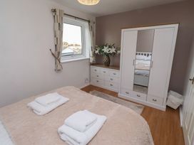 A bedroom with a bed and wardrobe at Beadlin cottage Beadnell