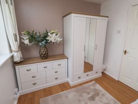 A bedroom with a chest of drawers and a wardrobe at Beadlin cottage Beadnell