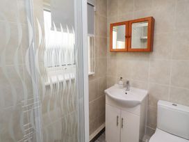 A bathroom with a shower, sink, and toilet at Beadlin cottage Beadnell