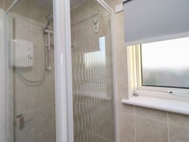 A shower area with window and showerhead at Beadlin cottage Beadnell