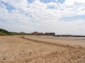 A beach with sand and boats at Beadlin cottage in Beadnell